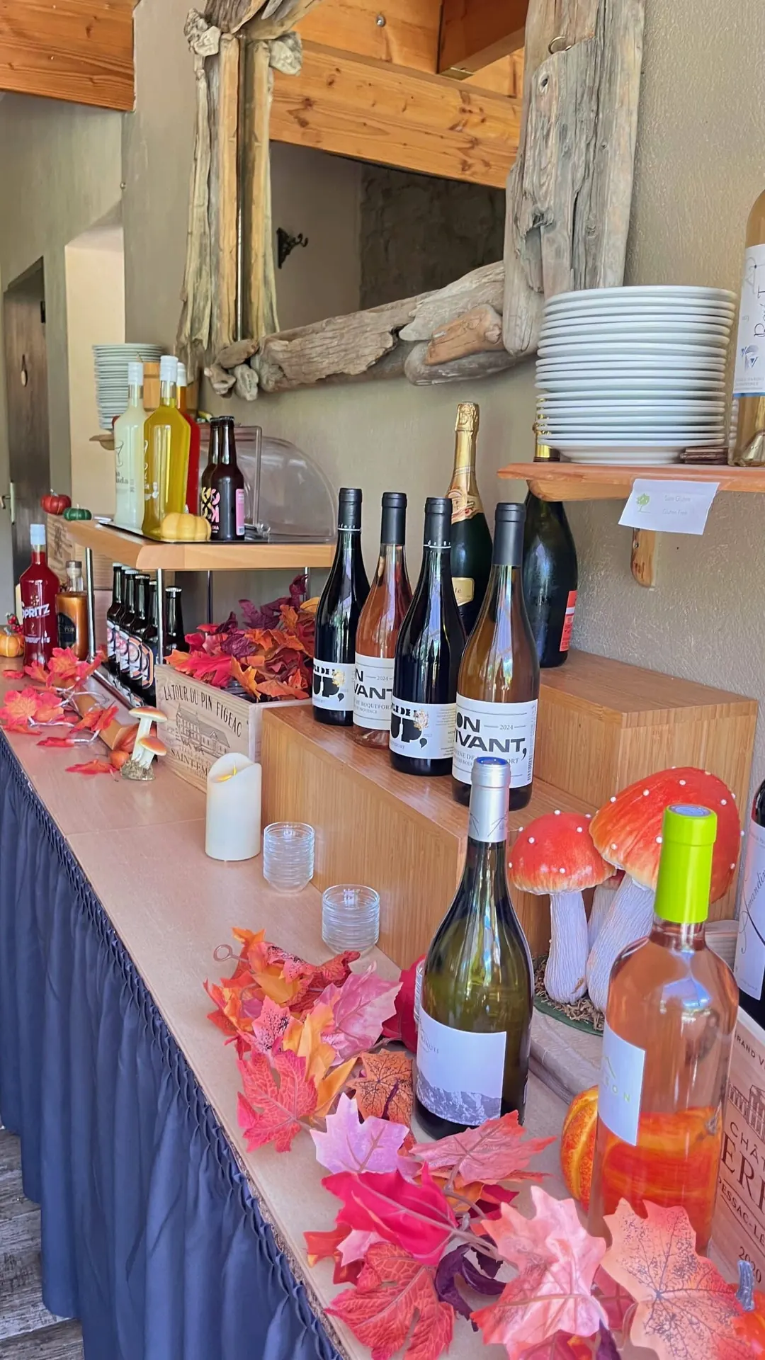 Bouteilles de vin, champignons décoratifs et feuilles rouges sur le bar