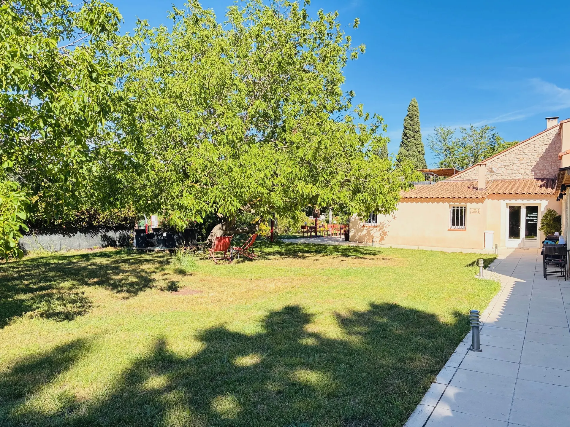 Jardin, pelouse et arbres devant le bâtiment de l'hôtel