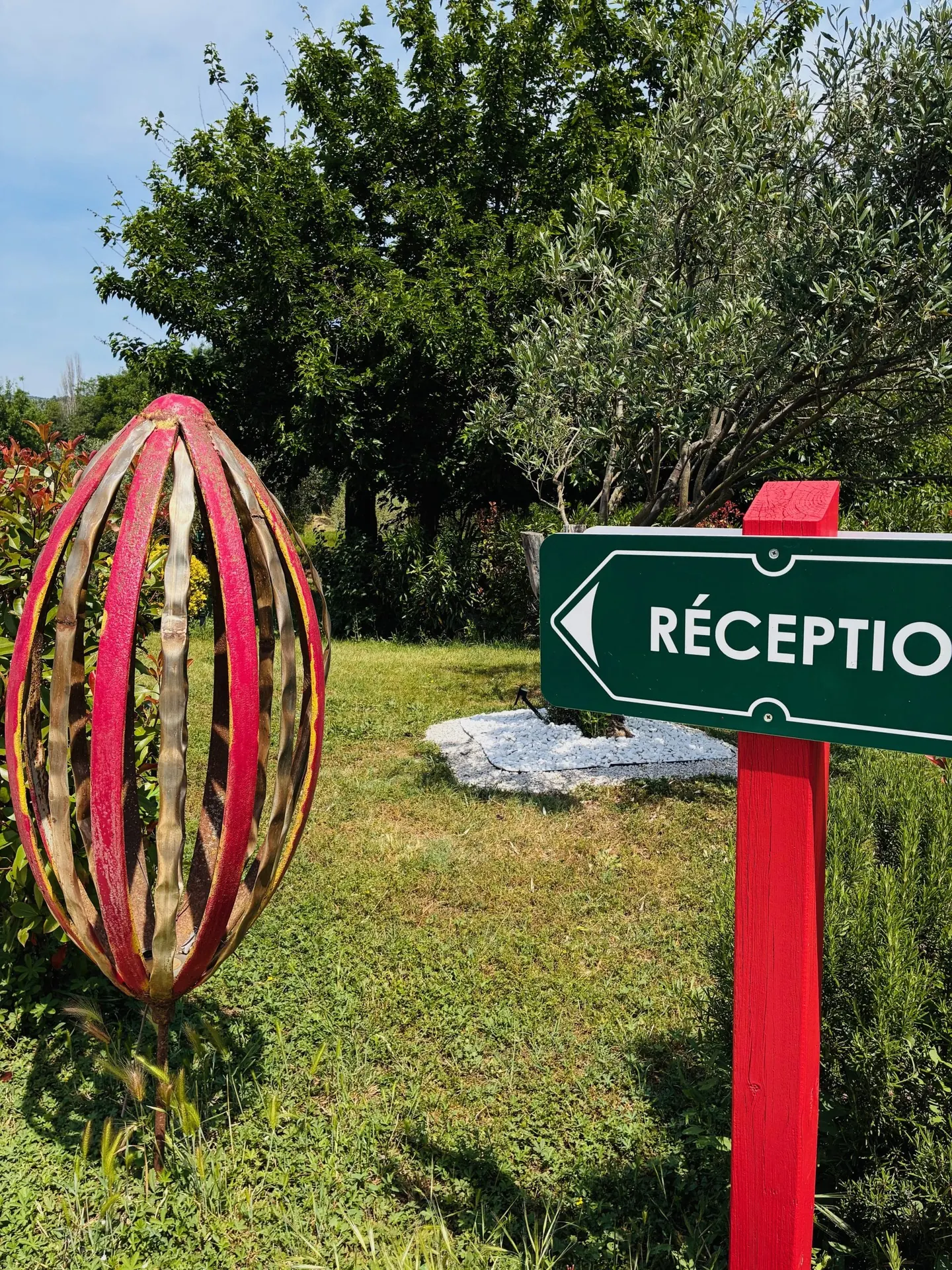 Panneau « Réception » et sculpture en bois dans le jardin