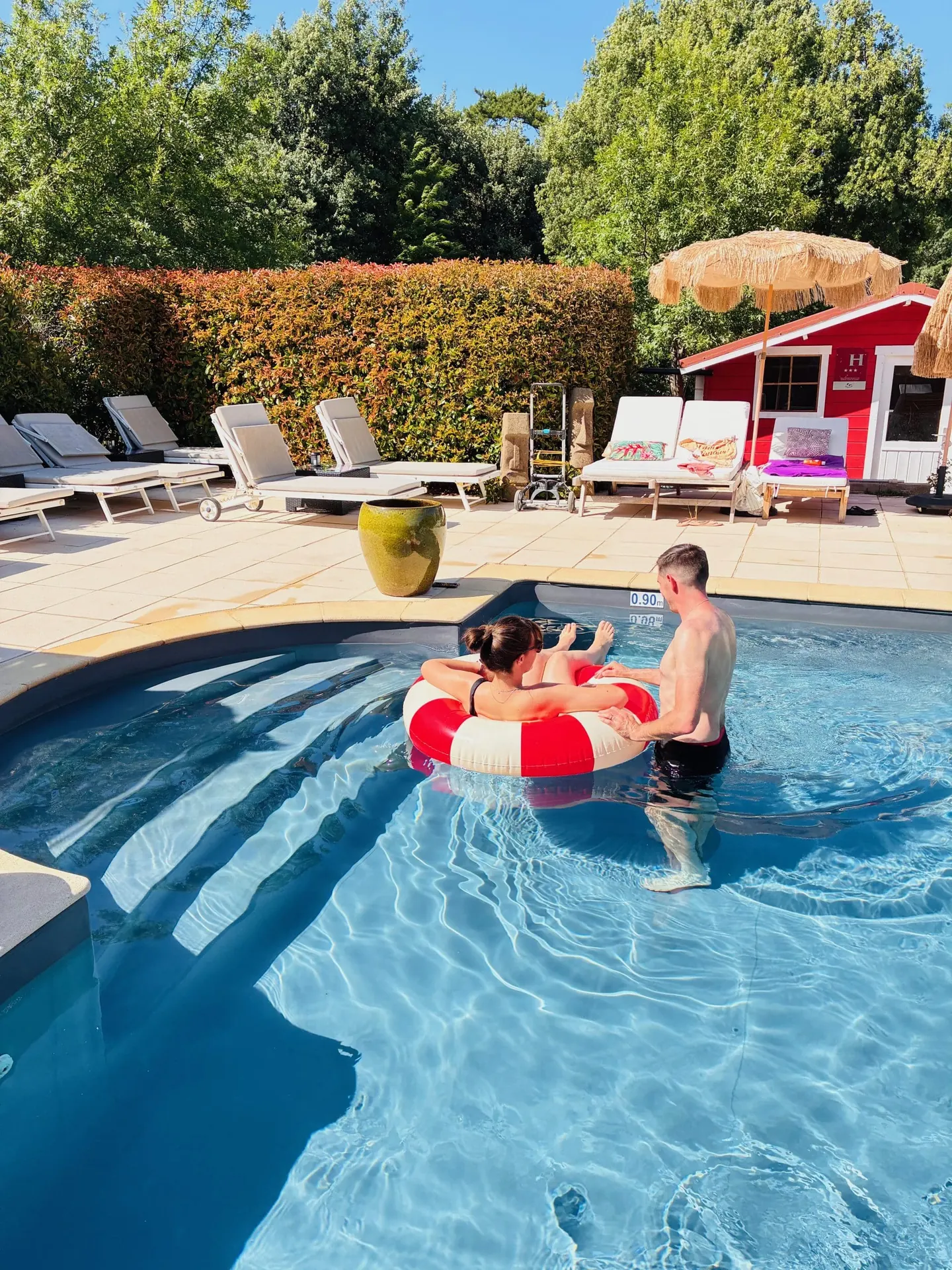 Couple dans la piscine avec une bouée rouge et blanche