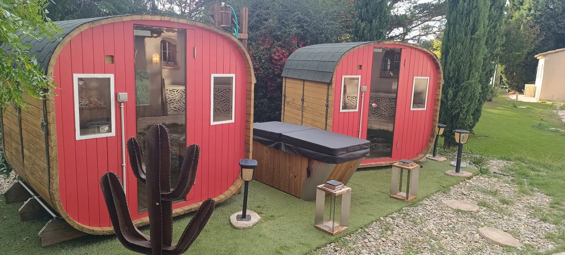Saunas tonneaux rouges et jacuzzi dans le jardin du spa L'Arbre à Vie